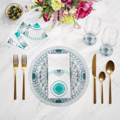 Dining table setting with decorative plates, cutlery, and flowers on a marble surface.