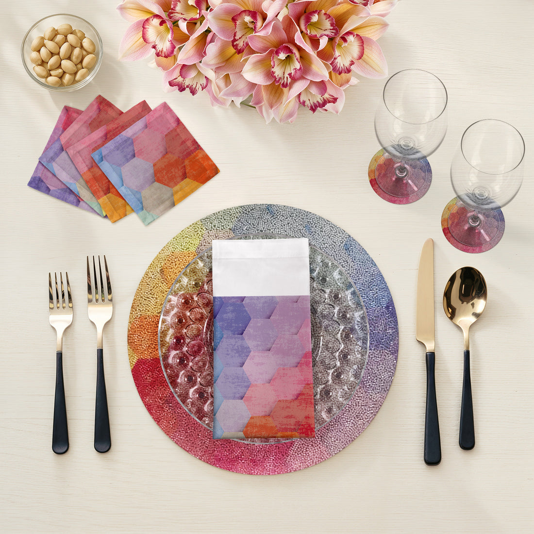 Colorful table setting with a plate, cutlery, and napkins on a white surface.