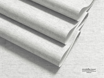 Three rolled sheets of textured wallpaper with a fine gray and white linen-like pattern, arranged diagonally on a matching flat surface. The brand name &